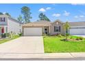 Inviting single-story home featuring an attached garage, manicured lawn, and charming curb appeal at 747 Gryffindor Dr., Longs, SC 29568