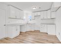 Bright kitchen featuring all white cabinets, countertops, and light wood-look floors at 9616 Sullivan Dr., Murrells Inlet, SC 29576