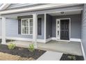 Inviting front porch with classic columns, black shutters, and attractive landscaping at 1013 Woodside Dr., Conway, SC 29526