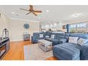 Spacious living room featuring a plush blue sectional, hardwood floors, ceiling fan, and an open floor plan at 113 B Vista Dr., Murrells Inlet, SC 29576