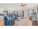 Inviting living room featuring a blue sectional, hardwood floors, and large windows with blue curtains at 113 B Vista Dr., Murrells Inlet, SC 29576