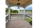 A covered porch overlooks a serene lake and lush greenery in the distance at 1348 Rue De Jean Ave., Myrtle Beach, SC 29579