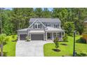 Stunning two-story home with lush green lawn, two-car garage, and inviting front porch at 209 Bouquets Green Way, Myrtle Beach, SC 29579
