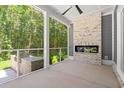 Cozy screened porch with brick fireplace, granite countertop grill station, and wood views at 209 Bouquets Green Way, Myrtle Beach, SC 29579