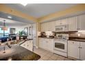 Modern kitchen with white cabinets, granite countertops, tile backsplash, stainless steel appliances, and a double sink at 2151 Bridge View Ct. # 2-803, North Myrtle Beach, SC 29582