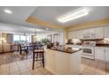 Open-concept kitchen boasts white cabinetry, dark countertops, tile backsplash, and views of the dining and living areas at 2151 Bridge View Ct. # 2-803, North Myrtle Beach, SC 29582