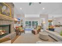 Bright living room with fireplace, plush seating, and large windows offering scenic backyard views at 25 Northwoods Ct., Pawleys Island, SC 29585