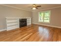 Bright living room featuring hardwood floors, a fireplace with built-in shelving, and a large window at 2600 Henagan Ln., Myrtle Beach, SC 29588