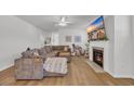 Spacious living room featuring a fireplace, light wood floors and a plush sectional sofa at 302 Portofino Dr., Myrtle Beach, SC 29579