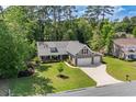 An aerial view reveals a beautiful home with a long driveway and lush green surroundings at 370 Foxtail Dr., Longs, SC 29568
