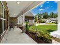 Inviting front porch with brick columns, bench seating, and manicured landscaping at 370 Foxtail Dr., Longs, SC 29568