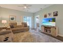 Comfortable living room featuring wood-look floors, a ceiling fan, access to the porch, and a TV with barnwood stand at 3766 Bells Lake Circle # 3766, Longs, SC 29568