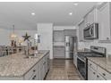 Modern kitchen with granite countertops, stainless steel appliances, and a seamless connection to the dining area at 396 Emery Oak Dr., Murrells Inlet, SC 29576
