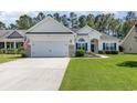 Charming single-story home featuring a well-manicured lawn and an attached two-car garage at 404 Windermere Lake Circle, Conway, SC 29526