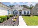 Well-maintained home with manicured landscaping and a walkway leading to the front entrance at 404 Windermere Lake Circle, Conway, SC 29526