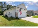 Exterior of a garage with brick accents, an American flag, and a backup generator on a grassy lawn at 404 Windermere Lake Circle, Conway, SC 29526