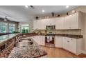 Well-lit kitchen featuring white cabinets, granite countertops, stainless steel appliances and hardwood floors at 4363 Parkland Dr., Myrtle Beach, SC 29579