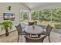 Cozy screened-in porch with tile flooring, a table with chairs, and beautiful backyard views at 442 Mahogany Dr. # 101, Murrells Inlet, SC 29576