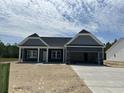 New construction home featuring a stylish exterior, an attached garage, a concrete driveway, and a manicured lawn at 4762 Huckleberry Ln., Conway, SC 29526