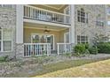 Cozy patio with white railings, beautiful brick, and lush landscaping for outdoor enjoyment at 4771 Wild Iris Dr. # 103, Myrtle Beach, SC 29577