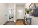 Inviting entryway with wood floors, a stylish console table, modern decor, and a glimpse into a bedroom at 861 Farmers Passage Loop, Loris, SC 29569