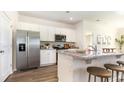 Modern kitchen featuring white cabinets, granite countertops, stainless steel appliances, and barstool seating at 861 Farmers Passage Loop, Loris, SC 29569