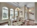 Dining area with natural light, hardwood floors, complemented by the arched windows and decorative chandelier at 9060 Abingdon Dr., Myrtle Beach, SC 29579