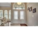 An entryway with decorative glass doors, a transom window, and dark hardwood floors offers an inviting introduction to the home at 9060 Abingdon Dr., Myrtle Beach, SC 29579