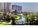 Scenic view of the waterway and buildings in the complex, with trees and a charming wooden bridge at 9840 Queensway Blvd. # 1819, Myrtle Beach, SC 29572