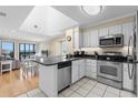 Modern kitchen with stainless steel appliances, black granite countertops, and white cabinetry at 108 N Ocean Blvd. # 301, North Myrtle Beach, SC 29582