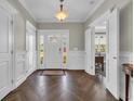Inviting foyer with wood floors, white wainscoting, coat closets, and a glimpse into the adjacent office space at 1136 Doubloon Dr., North Myrtle Beach, SC 29582