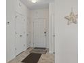 Bright entryway featuring neutral tile floors, white doors, and a decorative starfish hanging on the wall at 2090 Cross Gate Blvd. # 205, Surfside Beach, SC 29575