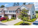 Inviting townhome with brick and siding facade, featuring a private garage and landscaped front yard at 260 Connemara Dr. # E, Myrtle Beach, SC 29579