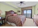 Comfortable bedroom with a ceiling fan, soft carpet and access to a private balcony with ocean views at 2600 N Ocean Blvd. # 1103, Myrtle Beach, SC 29577
