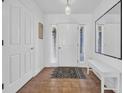 Bright entryway featuring a white front door, tiled floors, and a minimalist bench with mirror at 4104 Friendfield Trace, Little River, SC 29566