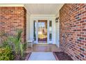 Beautiful brick home entrance with a glass paneled door and sidelights, complemented by a tiled porch at 4104 Friendfield Trace, Little River, SC 29566