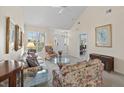 Comfortable living room with a vaulted ceiling, plush floral sofas, and a view of the front entrance at 432 Warrington Way # 432, Murrells Inlet, SC 29576