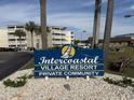 A sign for Intercoastal Village Resort Private Community sits in front of a building and palm trees at 4350 Intercoastal Dr. # 2302, Little River, SC 29566