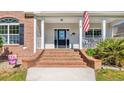 Close up of the brick steps leading up to the covered front porch and black front door at 4524 Ramsey Ford Rd., Tabor City, NC 28463