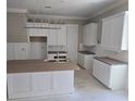 Spacious kitchen with white cabinets, center island, and modern lighting fixture at 507 Hillside Dr. N, North Myrtle Beach, SC 29582