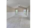 Bright, airy living room featuring wainscoting, a ceiling fan, and ample natural light from the windows at 507 Hillside Dr. N, North Myrtle Beach, SC 29582