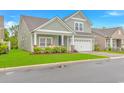 Charming two-story home with a well-manicured lawn and a two-car garage, plus inviting front porch at 5309 Abbey Park Loop, Myrtle Beach, SC 29579