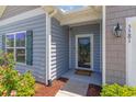 Inviting front entrance with a storm door, stylish exterior light and attractive landscaping at 5581 Plantersville Pl., Myrtle Beach, SC 29579
