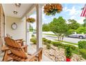 Inviting front porch with rocking chairs, hanging flower baskets, and stone ground cover with lush landscaping at 700 Lorenzo Dr., North Myrtle Beach, SC 29582