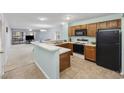 Open-concept kitchen with an eat-in bar, black appliances and views of living room at 712 Dogwood Dr. S # 101, Surfside Beach, SC 29575