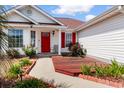 A warm and inviting home entrance with a well manicured lawn and bright red door at 761 Drawbridge Dr., Conway, SC 29526