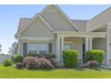 Close up of a home's well manicured lawn with mature landscaping surrounding the covered front porch at 853 Derbyshire Ct., Conway, SC 29526