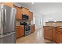 Modern kitchen featuring stainless steel appliances, wood cabinets, granite counters, and tile floors at 853 Derbyshire Ct., Conway, SC 29526