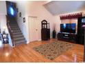 Bright living room with hardwood floors, staircase, large TV, and neutral decor at 916 Charles St., North Myrtle Beach, SC 29582