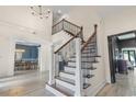 Elegant staircase with dark wood and wrought iron detailing in a light-filled foyer at 9449 Freewoods Rd., Myrtle Beach, SC 29588